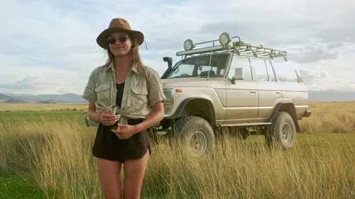 Woman by Off-Road Vehicle in Grassy Field