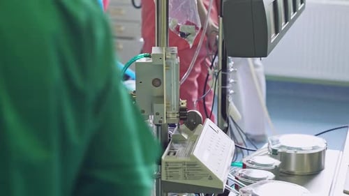 Medical Professional Adjusting Tubing on a Hospital Device