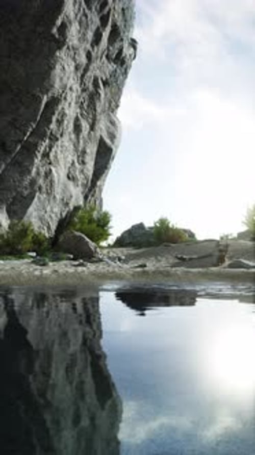 Massive Rock Face Towering Beside Water