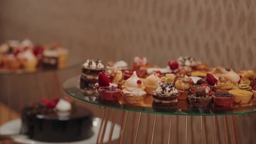 Hand Selecting Colorful Desserts at a Party