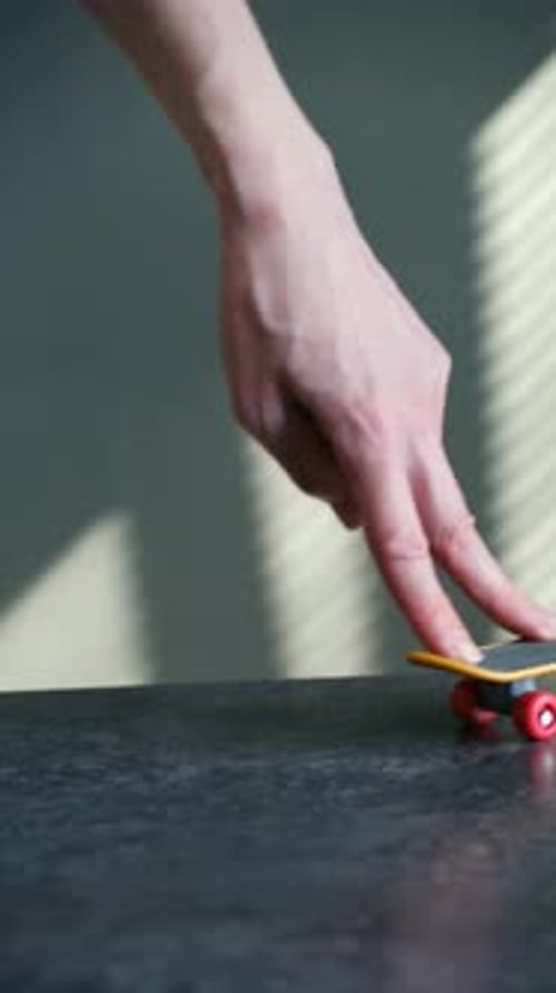Person Performing Tricks on a Miniature Fingerboard Skateboard