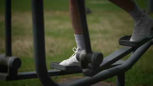 Legs Exercising on Gym Machine in Urban Park