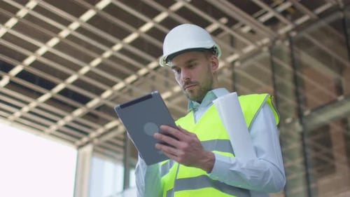 Männlicher Ingenieur mit Tablet-Computer. Glasgebäude oder Wolkenkratzer im Bau im Hintergrund
.