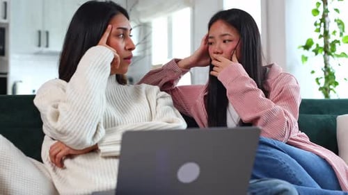 Two Young Women work Together on Laptop at Home