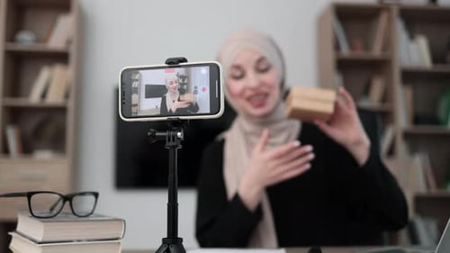 Woman Recording Video Holding a Box Indoors