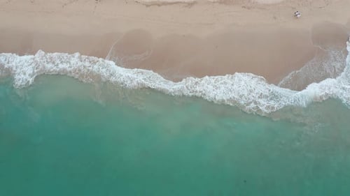 Tropical beach aerial view - bird's eye view. Top view of waves break on tropical white sand beach f