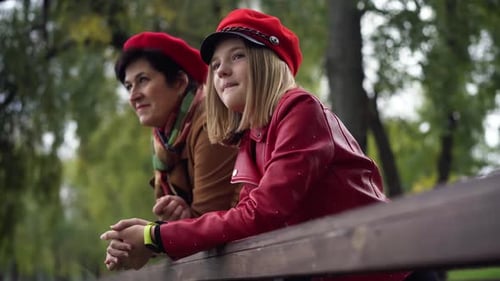 Portrait of Relaxed Teenage Granddaughter Smiling Leaning on Wooden Fence Talking with Senior
