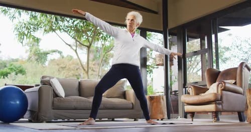 Senior Woman Practices Yoga in Indoor Space
