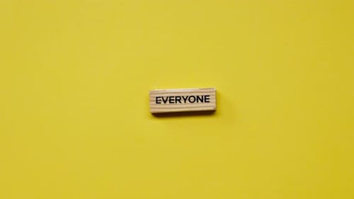 a Yellow Warm Background Without Shadows the Male Hand Laid Wooden Cubes with Colored Words Laid Out