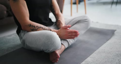 Young Adult Practicing Meditation on Yoga Mat