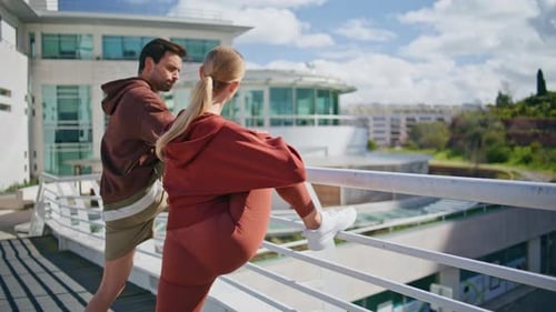 Couple Stretching Legs on City Rooftop