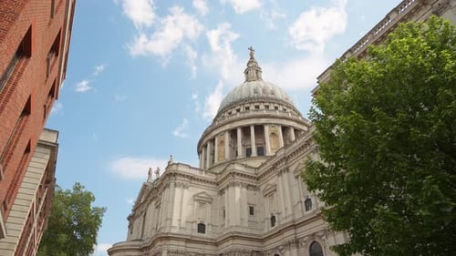 The Dome of St. Paul's Cathedral rising above the trees with a clear blue sky in the background in L
