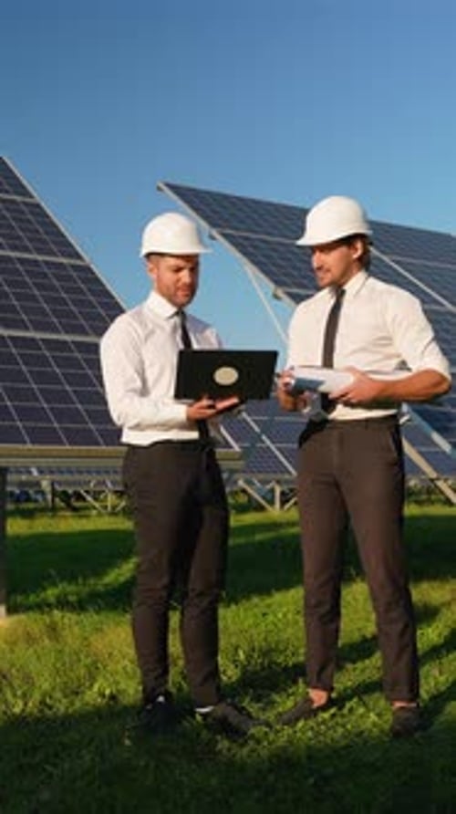 Two Engineers Discuss Solar Panel Performance on Site