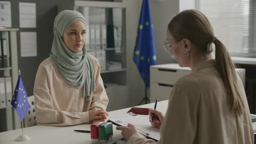 Woman in Hijab Having Visa Interview with Consular Officer in EU Embassy
