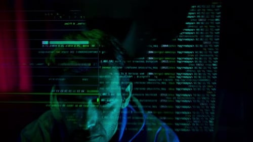 Un hacker anónimo con una máscara y una sudadera con capucha interactúa con datos digitales en un cuarto oscuro