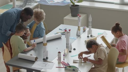 Little Kids and School Teacher Making Paper Rockets in Classroom
