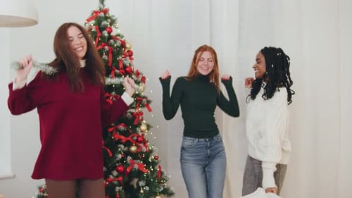 Three Women Dancing by Christmas Tree Indoors