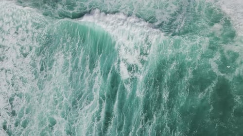 Aerial view of ocean waves crashing on beach, Portugal.