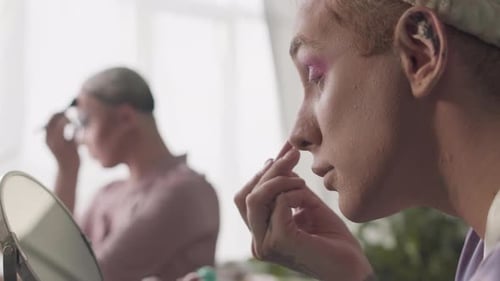 Two Young Queer Men Doing Drag Makeup Indoors