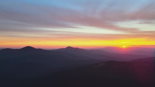 Beautiful Mountain Panoramic Landscape with Hazy Peaks and Foggy Valley at Sunset