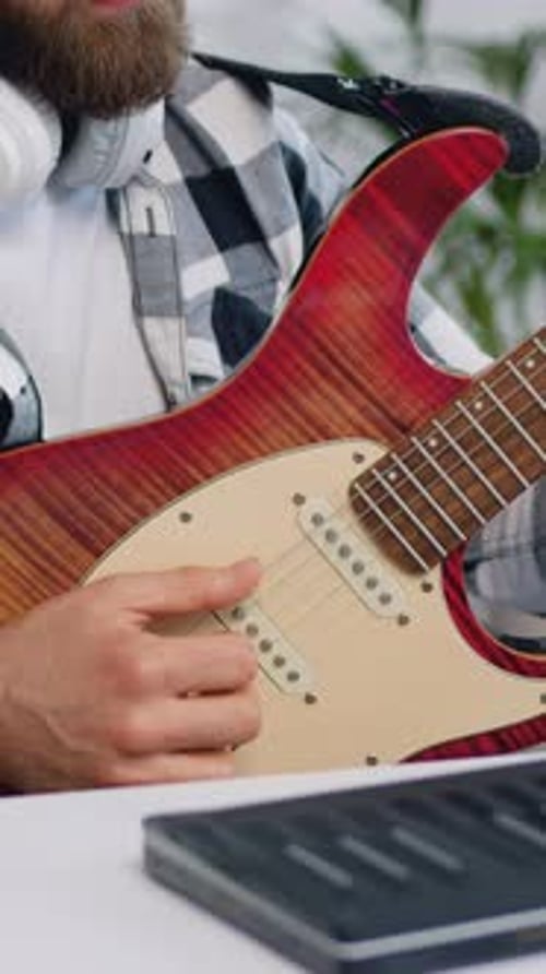 Close Up of Caucasian Young Bearded Man with Headphones Having Online Electric Guitar Class at Home