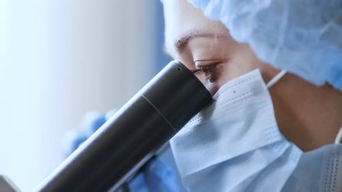 Healthcare Worker Uses Microscope in Laboratory