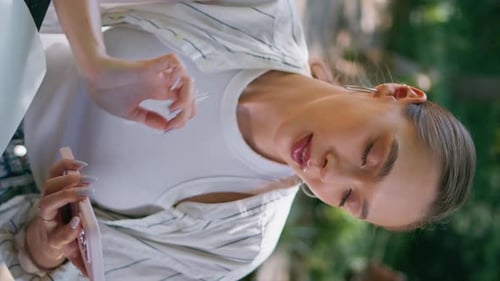 Relaxed Girl Scrolling Smartphone Searching Information at Park Closeup Vertical