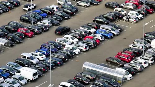 Large parking lot with many parked cars.