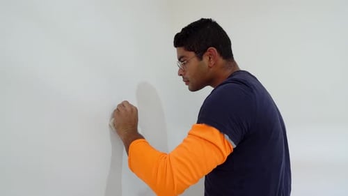 Young Adult Repairing Drywall Wall With Sponge