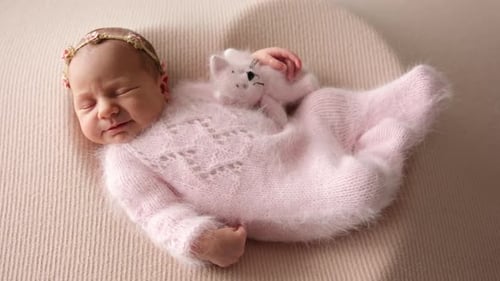 Adorable Sleeping Newborn Baby Girl Sleeping With Knitting Toy