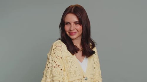 Woman Poses Smiling in Front of Plain Backdrop
