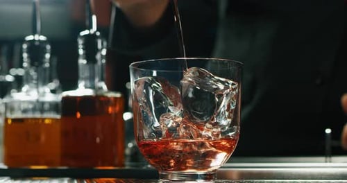 Close up of a professional bartender is preparing an alcoholic cocktail with professional crystal