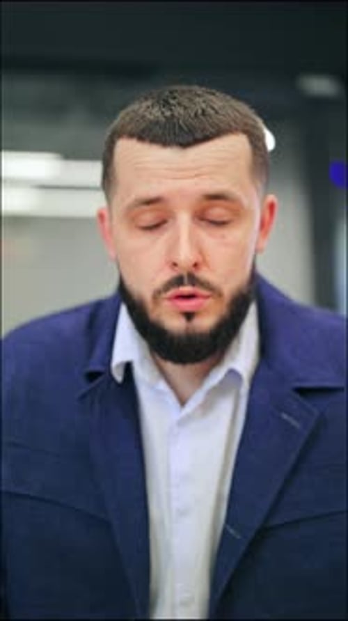 Man Looking Surprised Indoors Wearing a Blue Jacket