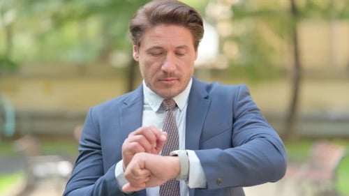 Businessman Using Smartwatch while Standing Outside Office
