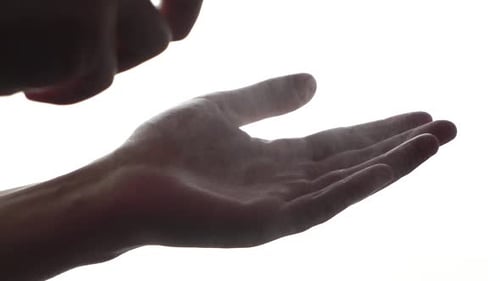 a man washes his hands with an antiseptic on a white background. close-up, slow motion.