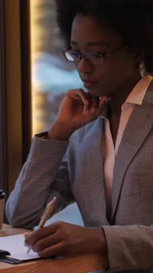 African Woman Working on Tablet at Cafe