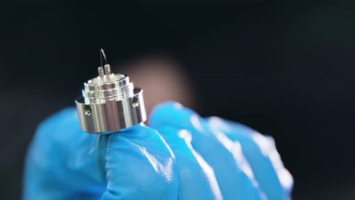 Close Up Hand showing piece of Microscope