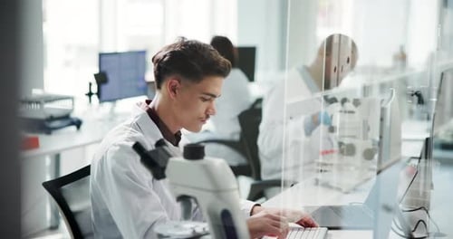 Young Adult Scientist Typing in a Bright Lab