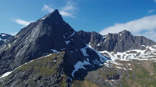 Explorando as montanhas cobertas de neve das Ilhas Lofoten do ar em um dia ensolarado. Noruega.
