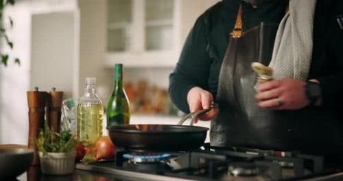 Man Cooks Food with Fire in a Frying Pan