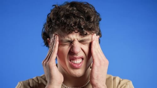 Young Man Having Headache Studio Portrait Guy Puts Hand on Head on Blue