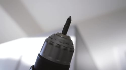 Slow motion close up of a drill spinning in the air while building ikea furniture
