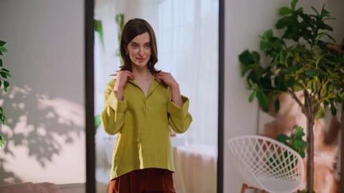Woman Styling Yellow Blouse in Mirror