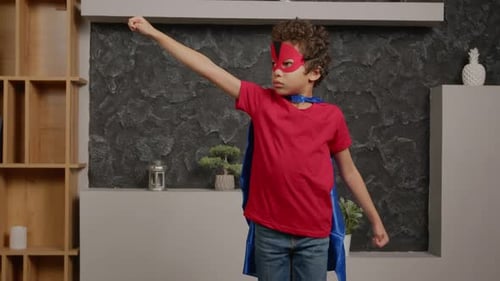 Determined School Age Boy in Superhero Costume Standing in Flying Pose