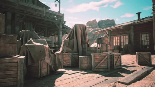 Abandoned Wooden Buildings Surrounded By Covered Crates in a Desert Landscape