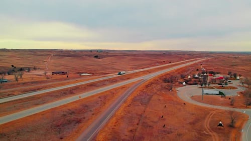 Wide aerial reveals a semi truck cruising along scenic Colorado highways near teepees and a desert-l