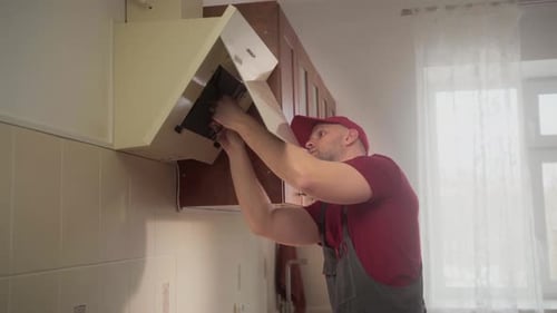 Handyman Installing Kitchen Extractor Hood Filter