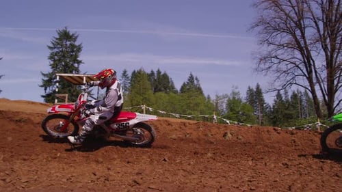 Motocross riders speeding through a dirt track turn in exciting outdoor competition