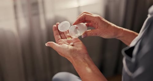 Senior Hands Pouring Pills From Bottle Into Hand