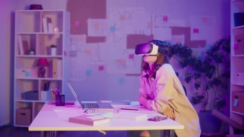 Young Adult Using Virtual Reality Headset at Desk